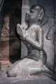 Orant aux pieds du dieu Srya en pierre sombre